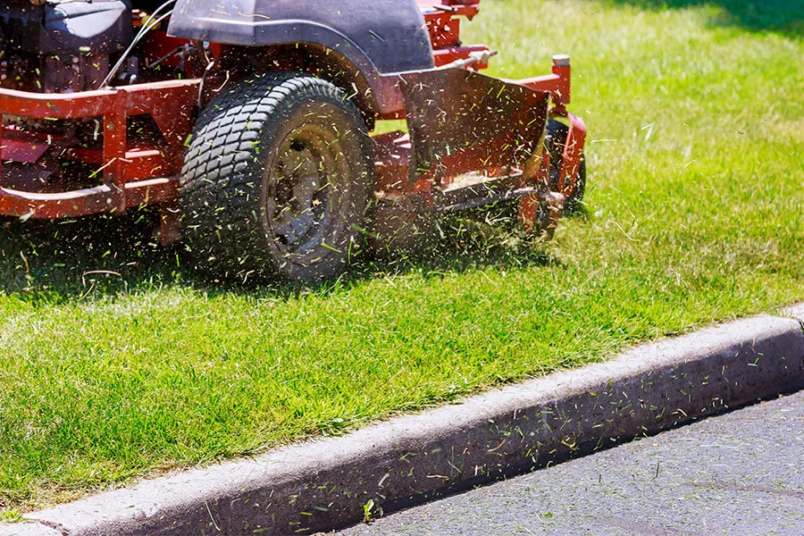 CJS Landscapes grounds maintenance operative strimming grass on a Sussex site